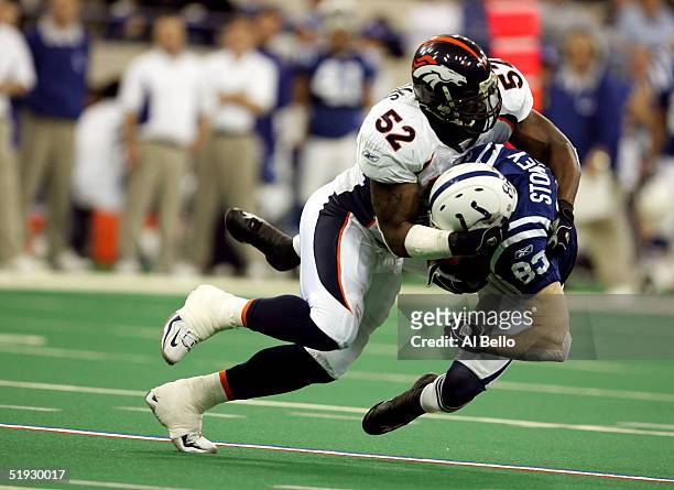 Brandon Stokley of the Indianapolis Colts is tackled by D.J. Williams of the Denver Broncos in the second quarter during the AFC Wildcard playoff...