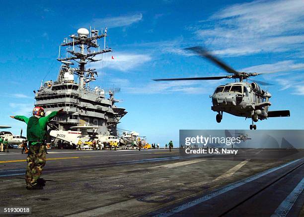 In this handout photo by the US Navy, a SH-60F Seahawk helicopter prepares to land on the flight deck aboard USS Abraham Lincoln on January 9, 2005...