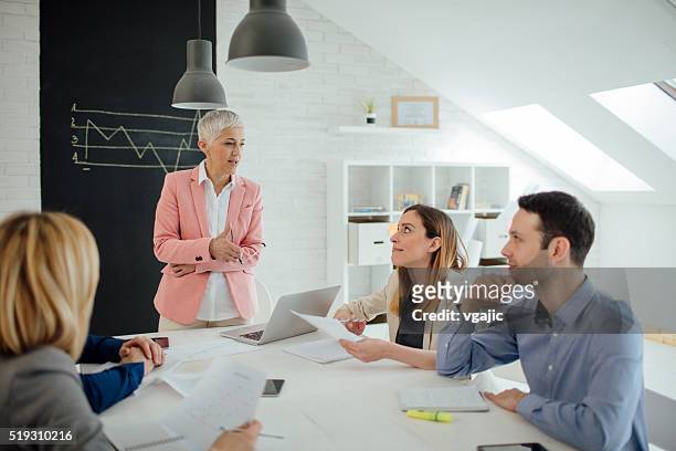 businesspeople having meeting in their office. - man met een groep vrouwen stockfoto's en -beelden