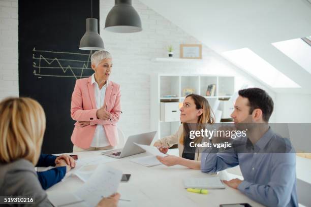 businesspeople having meeting in their office. - male with group of females stock pictures, royalty-free photos & images