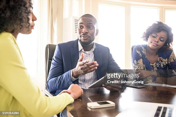 businessman and two female colleagues in meeting - nigeria stock pictures, royalty-free photos & images