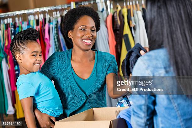 woman donates clothing to charity - clothing donation stock pictures, royalty-free photos & images