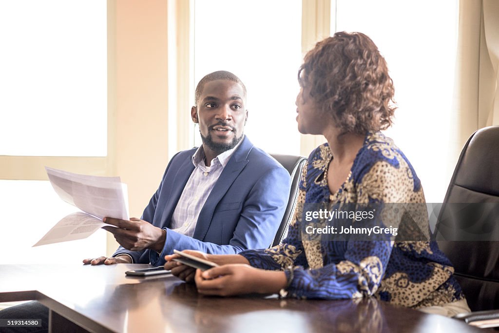 Nigerian business people in meeting with documents