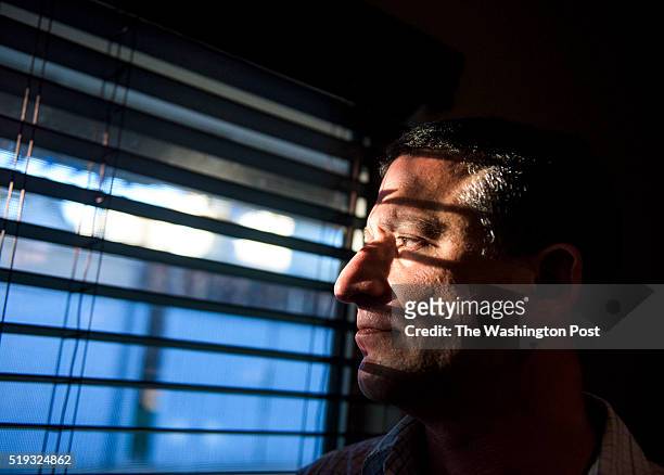 Keith Gartenlaub peers through blinds in the living room of his home in Southern California on Wednesday March 23rd. Gartenlaub has been charged with...
