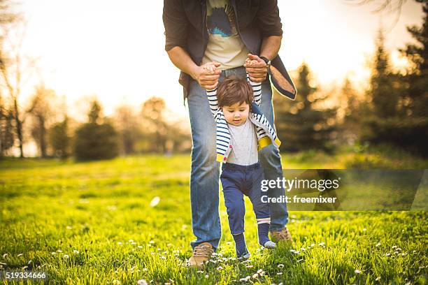 father and baby spending time together on the grass - één ouder stockfoto's en -beelden