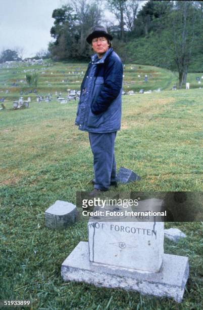 British film director Alan Parker stands in a cemetary, near a broken headstone, during the filming of 'Mississippi Burning,' Mississippi, 1988.