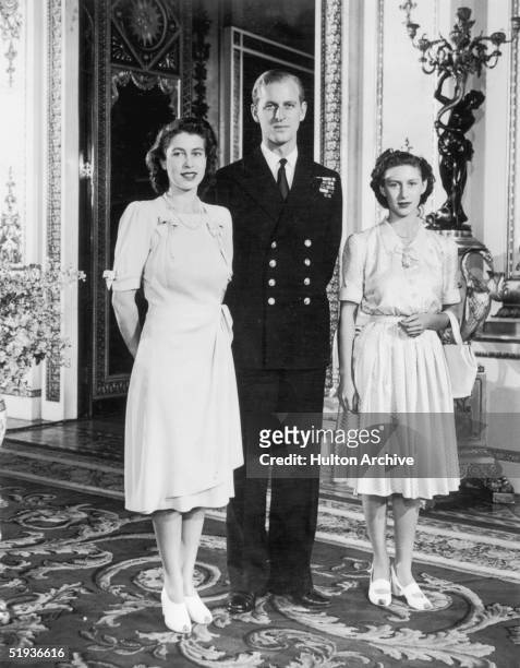Princess Elizabeth with her fiance Lieutenant Philip Mountbatten and her sister Margaret in the White Drawing Room of Buckingham Palace, September...