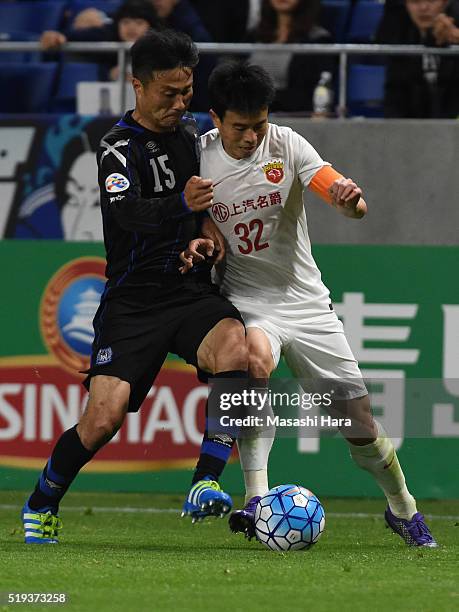 Yasuyuki Konno of Gamba Osaka and Sun Xiang of Shanghai SIPG compete for the ball during the AFC Champions League Group G match between Gamba Osaka...