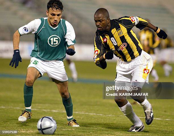 Saudi Al-Ittihad's Brazilian player Sergio fights for the ball with Al-Ahli's Yunes Ali of Qatar during their Arab Champions League match in Doha 11...