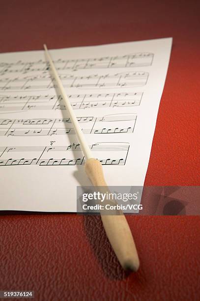 conductor's baton lying on music score - conductor's baton stock pictures, royalty-free photos & images