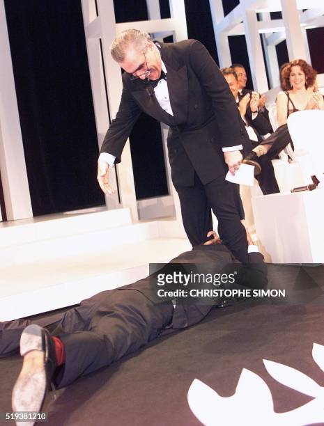 Italian director Roberto Benigni lays in front of US director and Jury president Martin Scorsese, 24 May at the final ceremony of the 51st Cannes...