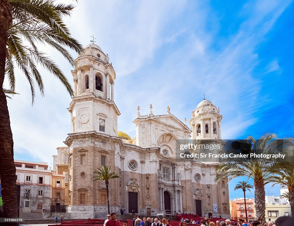 Cadiz Cathedral facade surrounded by palm trees in Andalusia, Spain