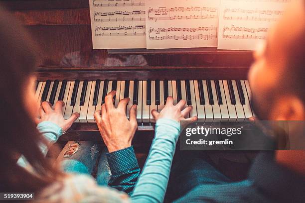 joven jugando juntos adultos de piano - pianista fotografías e imágenes de stock
