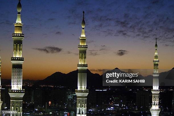 The minarets of the Prophet Mohammed Mosque are lit during the sunset prayers in the holy Saudi city of Medina 11 January 2005. Saudi Arabia began...