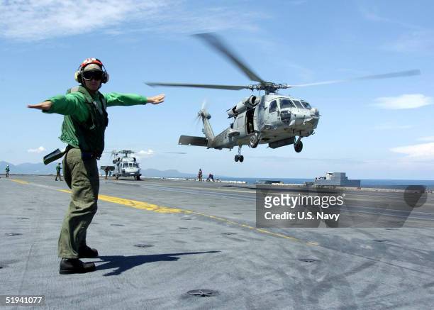 In this handout image provided by the U.S. Navy, a Landing Signals Enlisted man directs an HH-60H Seahawk, assigned to the "Golden Falcons" of...