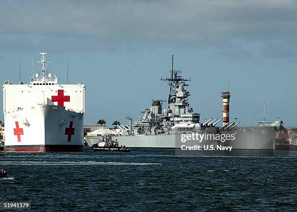 In this handout image provided by the U.S. Navy, the Military Sealift Command hospital ship USNS Mercy passes the battleship USS Missouri January 11,...