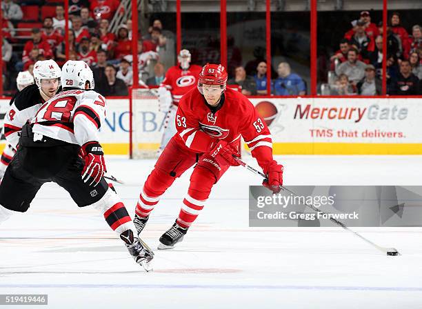 Jeff Skinner of the Carolina Hurricanes skates with the puck and controls it away from Damon Severson of the New Jersey Devils during an NHL game at...