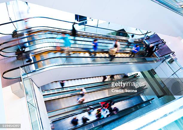 people rushing in escalators - mass consumerism stock pictures, royalty-free photos & images