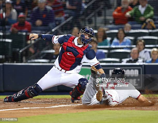 Third baseman Ryan Zimmerman of the Washington Nationals slides in safely past catcher A.J. Pierzynski of the Atlanta Braves to score the tying run...