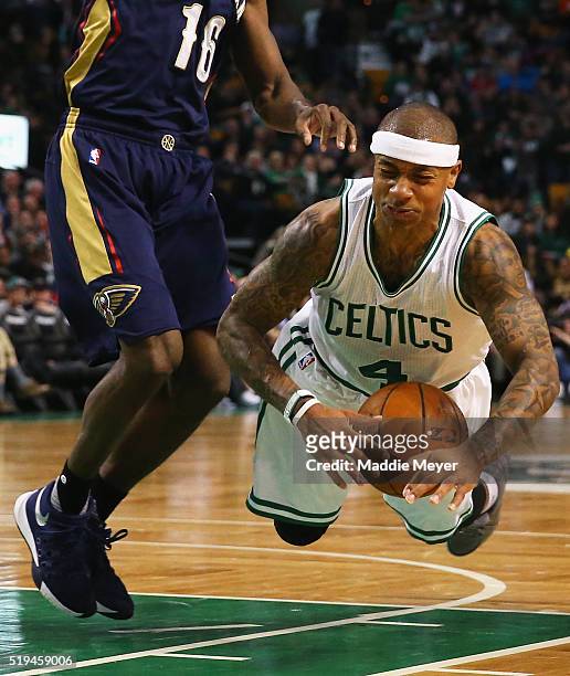 Isaiah Thomas of the Boston Celtics falls while driving against Toney Douglas of the New Orleans Pelicans during the third quarter at TD Garden on...