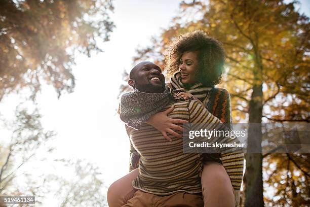 below view of african american couple piggybacking in nature. - park couple piggyback stock pictures, royalty-free photos & images