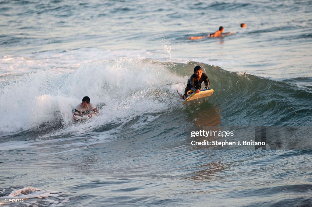 Children surf the waves in El Tunco. El Tunco is now the...