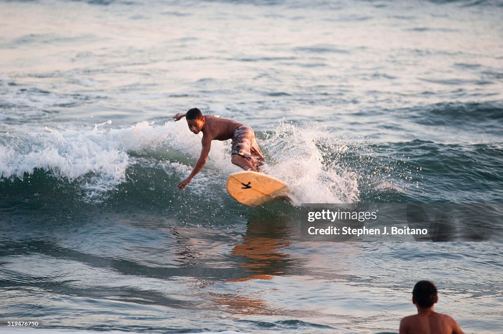 Children surf the waves in El Tunco. El Tunco is now the...