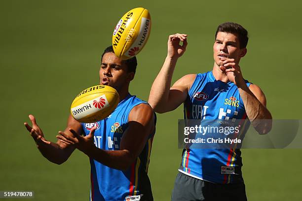 Touk Miller and Jaeger O'Meara handball during a Gold Coast Suns AFL training session at Metricon Stadium on April 7, 2016 in Gold Coast, Australia.