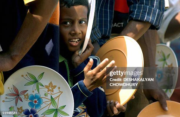 An Indian child waits his turn in a queue for midday meal distribution at a relief camp in Port Blair, 13 January 2005. The official death toll in...