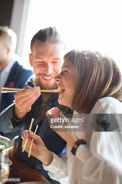 feeding with sushi - chopsticks stock pictures, royalty-free photos & images