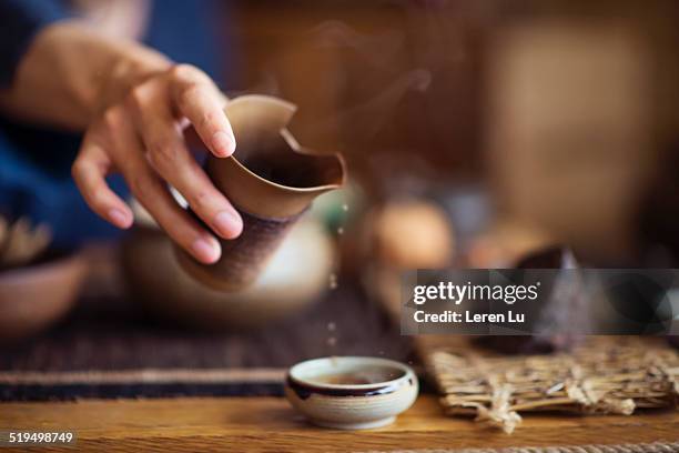 serving chinese tea into ceramic tea cups - traditioneller brauch stock-fotos und bilder
