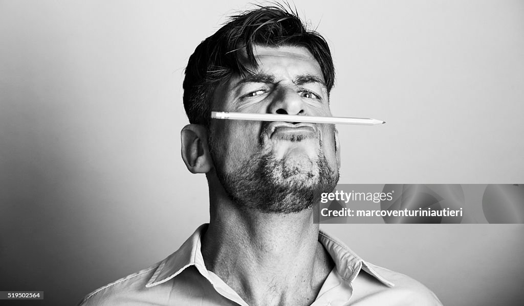 Mad artist holds a pencil with his lips