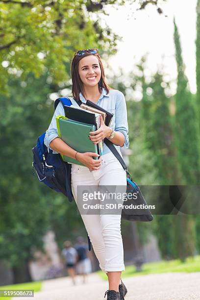 pretty college student walking to class with stack of books - stack of sun lounges stock pictures, royalty-free photos & images