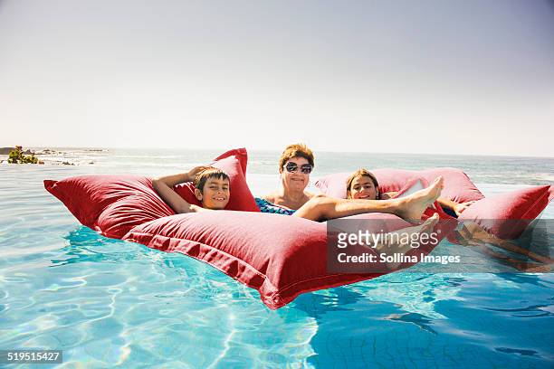 grandmother and grandchildren relaxing on pool raft - hot mexican girls stock-fotos und bilder