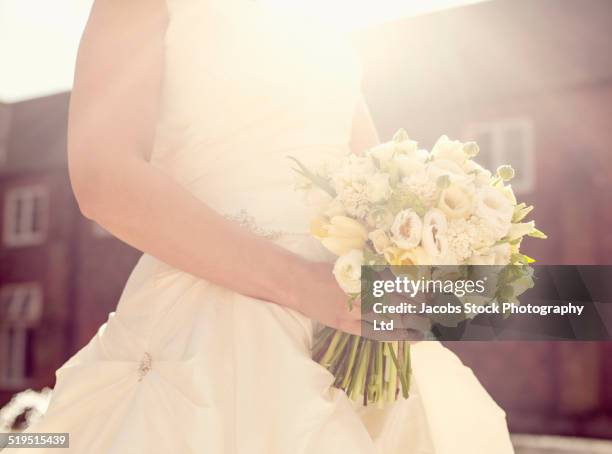close up of hispanic bride holding bouquet of flowers - ranunculus wedding bouquet stock pictures, royalty-free photos & images