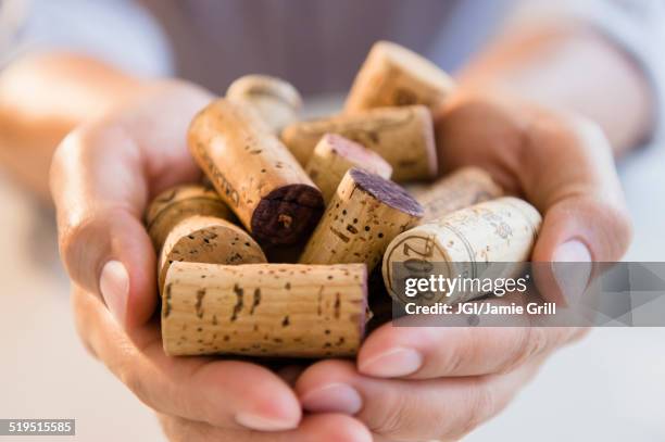 close up of mixed race man holding wine corks - korken stock-fotos und bilder