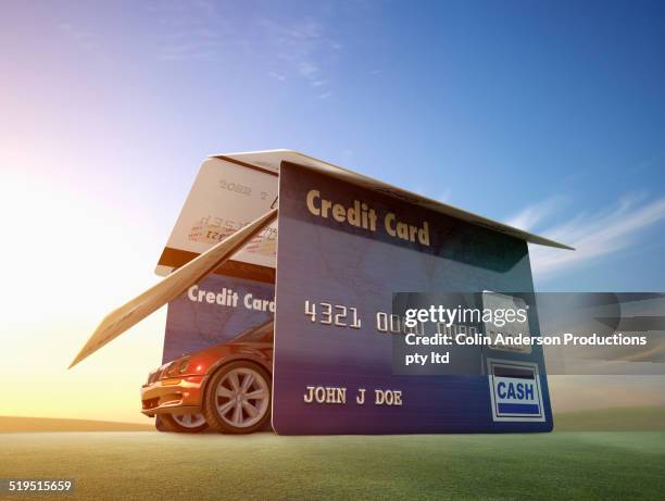 car driving out of garage made of credit cards - autokredit stock-fotos und bilder