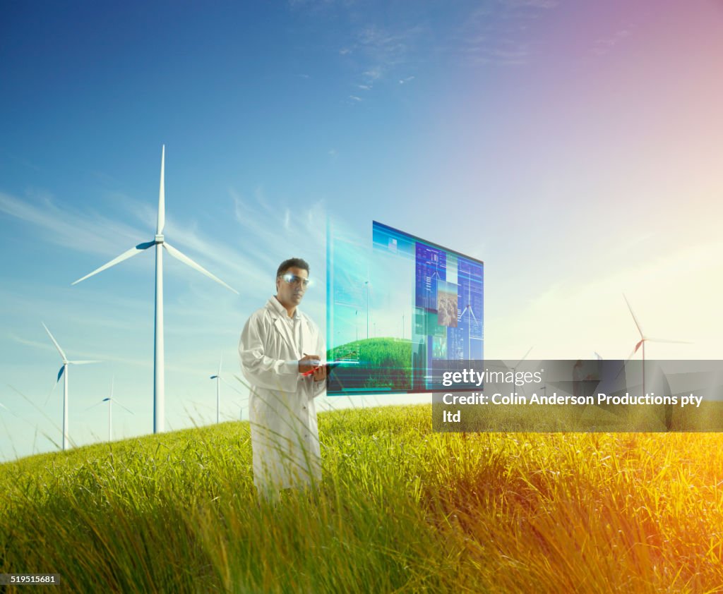 Mixed race scientist using holograph screen in field of wind turbines