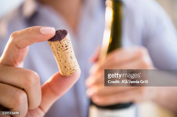 close up of mixed race man holding wine cork - wine corks stockfoto's en -beelden