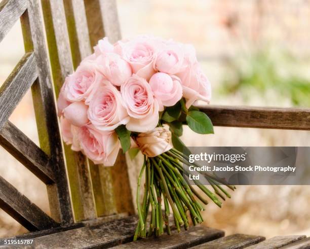 close up of bouquet of roses on wooden bench - rose ceremony stock pictures, royalty-free photos & images