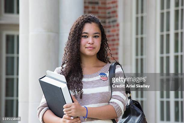 mixed race student carrying books - democracy book stock pictures, royalty-free photos & images