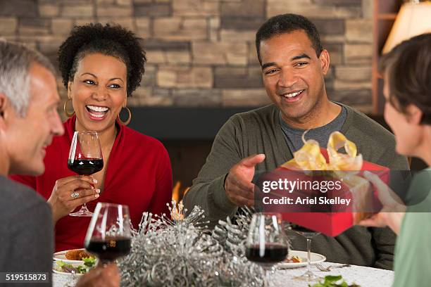 couples exchanging christmas gifts - covered food with wine stock pictures, royalty-free photos & images