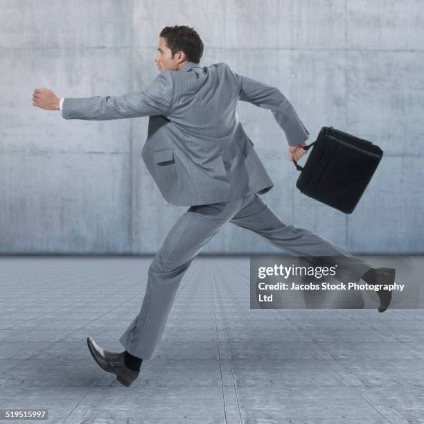 hispanic businessman running on concrete - striped suit 個照片及圖片檔