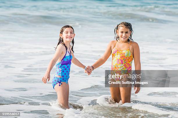 girls holding hands in ocean waves - hot mexican girls stock-fotos und bilder