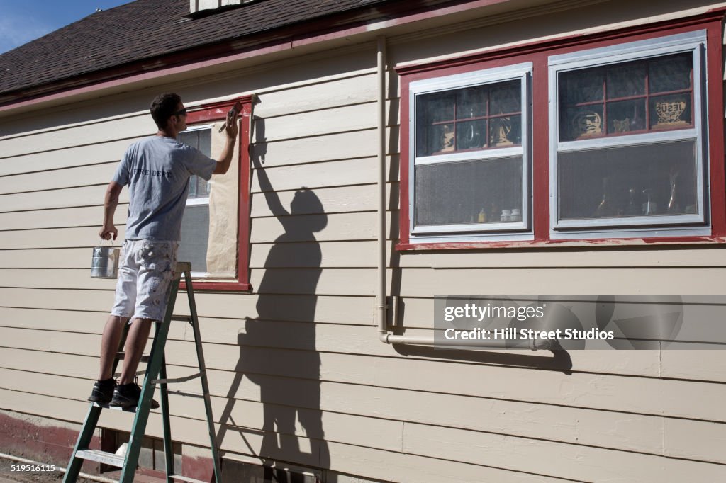 Caucasian man painting window frames