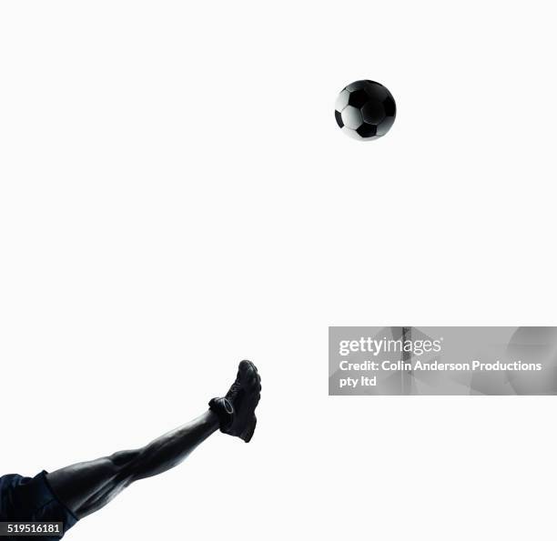 leg of black soccer player kicking ball - fussball freisteller stock-fotos und bilder