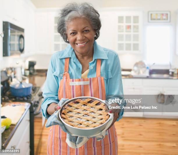 older african american woman baking pie in kitchen - american pie stockfoto's en -beelden