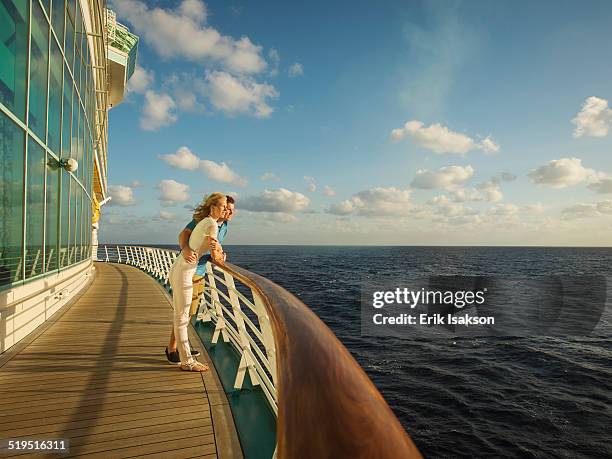 caucasian couple admiring view from boat deck - kreuzfahrt stock-fotos und bilder
