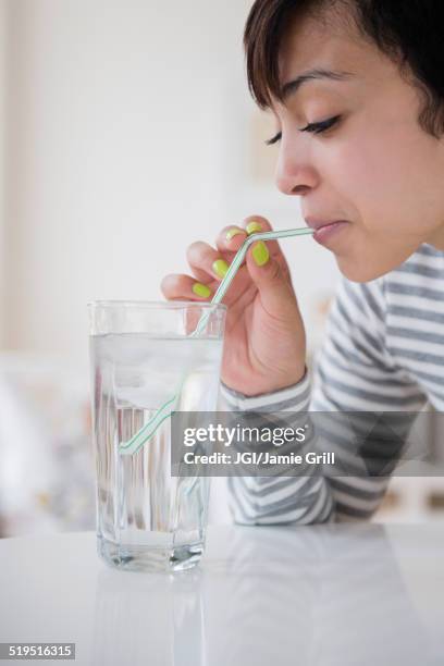 mixed race woman drinking water with straw - drinking straw stock pictures, royalty-free photos & images
