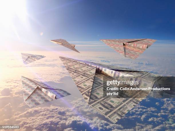 currency bills folded into paper airplanes in atmosphere - excess stock pictures, royalty-free photos & images
